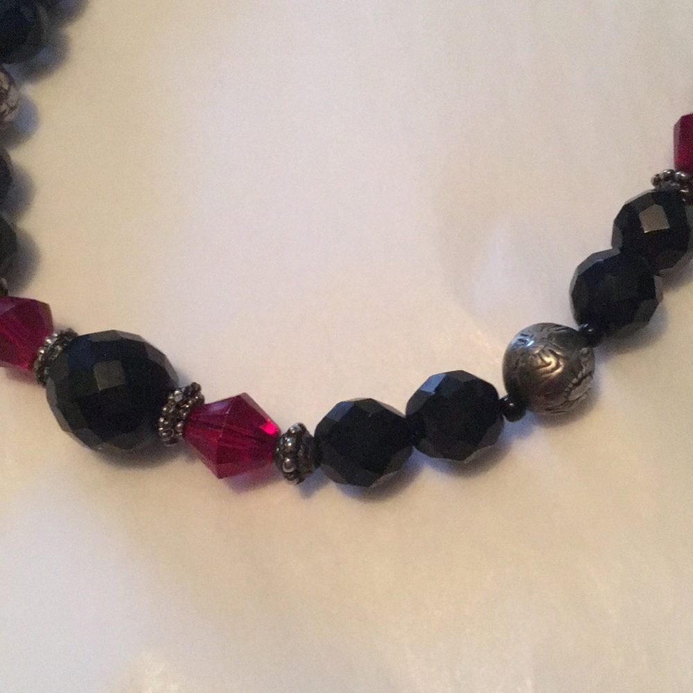 Vintage beaded necklace with red and black faceted beads and silvertone accents.